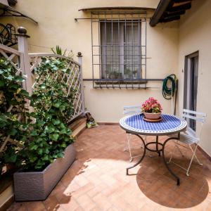 um pátio com uma mesa, cadeiras e plantas em San Pier Novello in Oltrarno em Florença