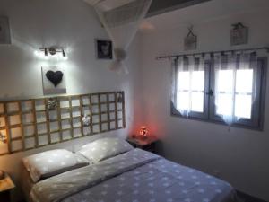 1 dormitorio con 1 cama y 2 ventanas en Villa F6 à 5 min de la plage, frontignan plage, en Frontignan