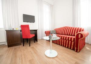 a living room with a red couch and a red chair at Gästehaus fliegendes Perlhuhn Borgfeld in Lilienthal