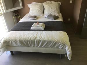 Una cama con sábanas blancas y una toalla. en Grande chambre chez l habitant, sanitaires partagés avec éventuels autres locataires, en Buros