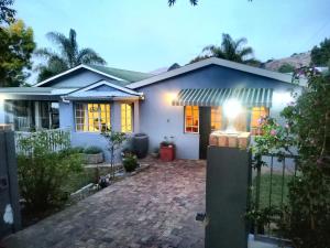 a white house with a brick driveway at Antique Silk Self Catering Unit in Grahamstown
