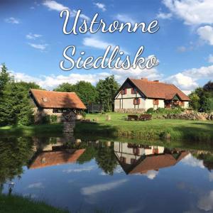 a house next to a lake with the words welcome sledisel at Ustronne siedlisko in Sorkwity