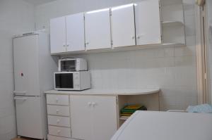 cocina con armarios blancos y nevera blanca en Javea Lovely Apartments Facing the Sea, en Jávea
