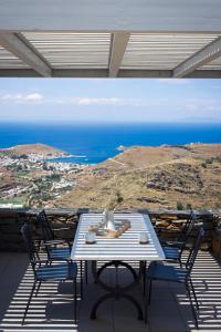 una mesa y sillas en un balcón con vistas al océano en Tetrapolis Keos en Milopótamos