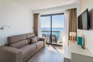 a living room with a couch and a view of the ocean at Occidental Fuengirola in Fuengirola