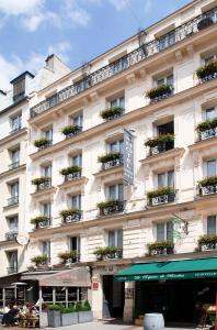 - un grand bâtiment blanc avec des boîtes de fleurs dans l'établissement Grand Hôtel Lévêque, à Paris