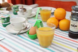een tafel met een glas sinaasappelsap en eieren bij Villa Waterland in Den Ilp