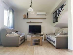 ein Wohnzimmer mit 2 Sofas und einem Flachbild-TV in der Unterkunft Vacation Home Naluka in Donji Morinj