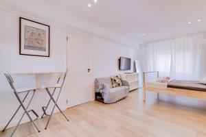 a white room with a bed and a chair at À da Avó -The Guesthouse in Faro