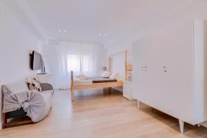 a white room with a bed and a mirror at À da Avó -The Guesthouse in Faro