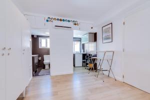 a kitchen and living room with white walls and wooden floors at À da Avó -The Guesthouse in Faro