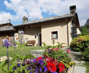 a garden in front of a house with flowers at L'Abreny in Brusson