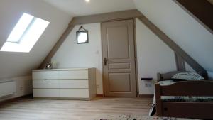 a bedroom with a door and a bed in a attic at La Vignellerie du Lac in Hommes +9 photos