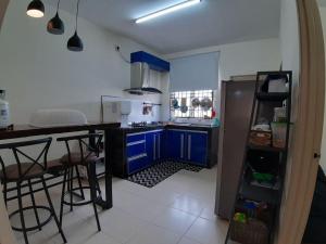 een keuken met blauwe kasten, een aanrecht en een koelkast bij ORCHIDD HOMESTAY in Gambang