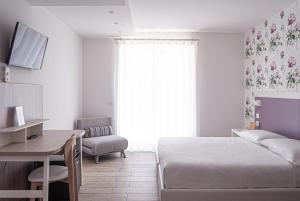 1 dormitorio con cama, escritorio y ventana en B&B FLORE, en Torre Maggiore