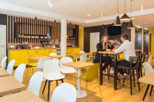 Dos mujeres sentadas en una mesa en un restaurante en Aparthotel Adagio Access Bruxelles Europe Aparthotel en Bruselas