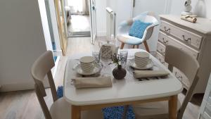 a white table and chairs in a room at Le Carpe Diem in La Forêt-Fouesnant