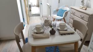 - une table et des chaises blanches dans la chambre dans l'établissement Le Carpe Diem, à La Forêt-Fouesnant