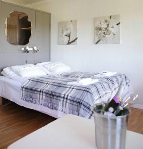 a bedroom with a bed and a table with a vase of flowers at Fjordslottet Hotel in Fotlandsvåg