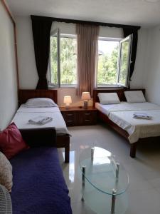 a room with two beds and a glass table at Apartments S&S in Konjic