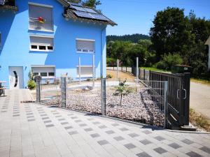 una valla frente a un edificio azul en Privatzimmer Sonne, en Bad Säckingen