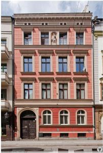 a red brick building with a horse in the window at Pokoje w cichym mieszkaniu 50m od Rynku in Wrocław
