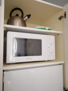 un forno a microonde bianco su una mensola in cucina di Mediterraneo Turin Centre a Torino
