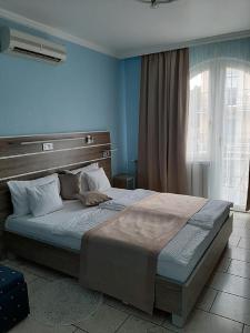 Un dormitorio con una cama grande con paredes azules. en Márvány Panzió, en Hajdúszoboszló 69 fotos más