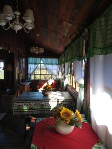 a bedroom with two beds and flowers on a table at Chalé Pedroso Monte Verde in Monte Verde