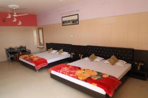 a bedroom with two beds with red blankets at Shivam Palace & Resort in Jodhpur