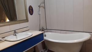 La salle de bains est pourvue d'un lavabo et d'une baignoire. dans l'établissement Sydney Motel, à Tucheng