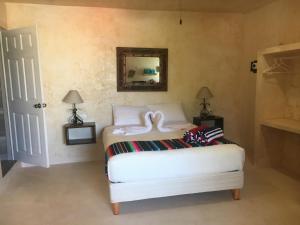 a bedroom with a white bed and a mirror at Villas Chukum in Isla Mujeres