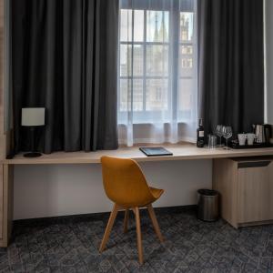 a desk with a chair in front of a window at Korona Hotel Wroclaw Market Square in Wrocław