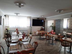 Un comedor con mesas y sillas y una mampara. en Márvány Panzió, en Hajdúszoboszló