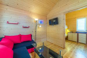 a living room with a red couch in a wooden room at Pod Gruszą Wicie in Wicie