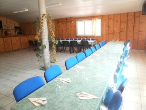 a conference room with a long table and blue chairs at Hotel Restaurant Lancheton in Saint-Julien-Mont-denis