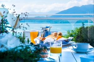 a table with a plate of food and orange juice at Impérial Palace in Annecy