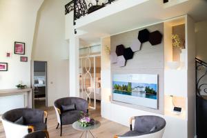 a living room with chairs and a tv on a wall at Impérial Palace in Annecy