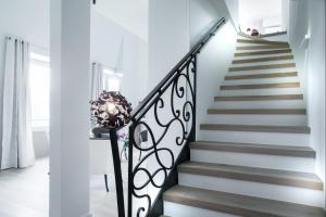 a staircase in a home with white walls and a wrought iron railing at Impérial Palace in Annecy