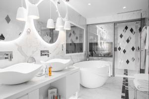 a white bathroom with two sinks and a tub at Impérial Palace in Annecy
