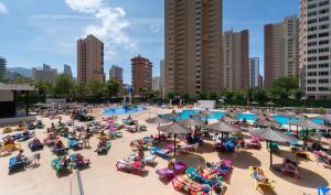 une foule de personnes assises sur des chaises à la piscine dans l'établissement Medplaya Hotel Rio Park, à Benidorm