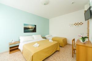 A bed or beds in a room at Albergo Roma Spiaggia