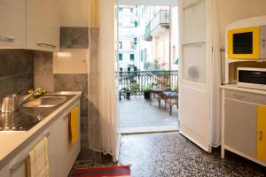 a kitchen with a sink and a door to a balcony at Corso Mazzini in Savona