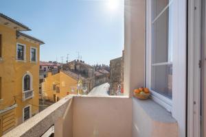 a bowl of oranges on a window sill with a view at Twins Idola Apartments in Pula