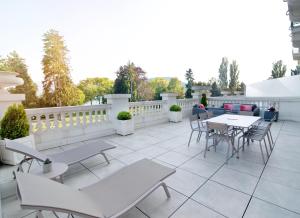 a patio with tables and chairs and a fence at Impérial Palace in Annecy