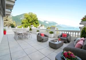a patio with couches and a table and chairs at Impérial Palace in Annecy