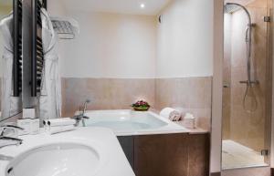 a bathroom with a tub and a sink and a shower at Impérial Palace in Annecy