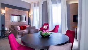 a living room with a table and red chairs at Impérial Palace in Annecy