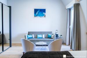 a living room with a couch and a table and chairs at Impérial Palace in Annecy