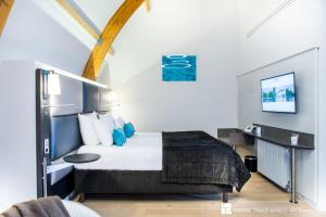 a hotel room with a bed and a tv at Impérial Palace in Annecy